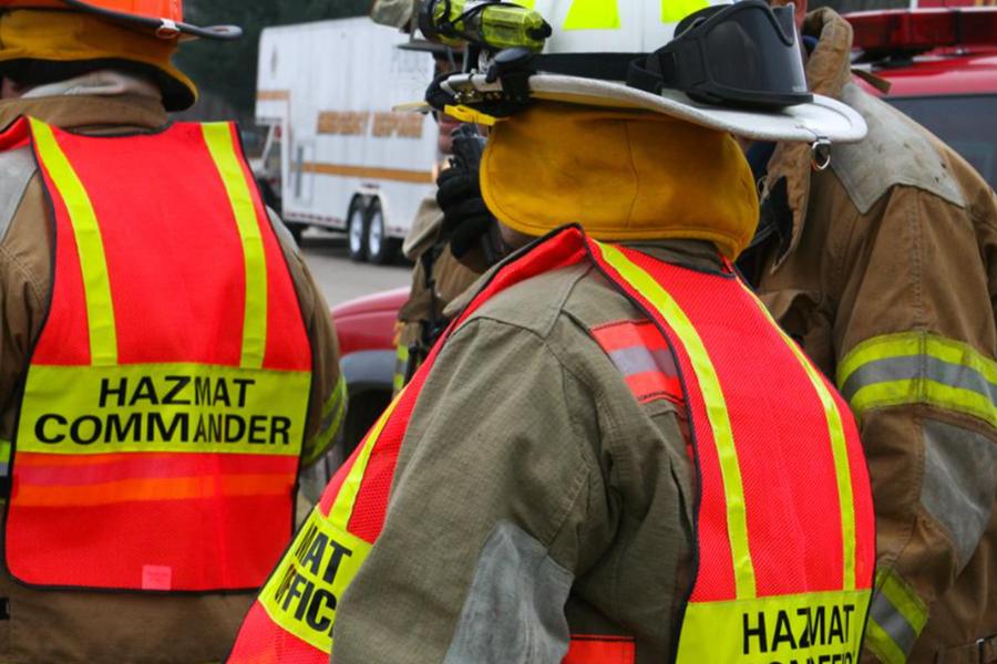 First responders in full protective gear and high-visibility vests labeled 