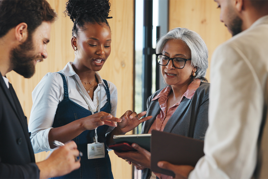 A diverse group of professionals collaborating in an engaged discussion in a modern workspace.